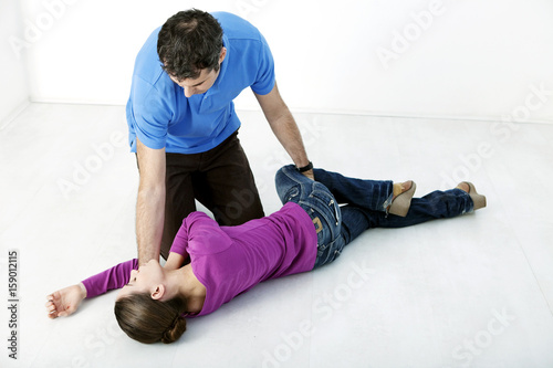 First aid techniques : placing the victim in the recovery position Step 4 : roll the victim by pulling on their leg until their knee touches the ground Remove your hand from the victim's head, holding their elbow so their hand stays in place