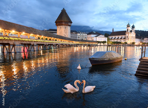 Chapel Bridge and Water Tower at night with swans on Lake Lucerne, Lucerne, Switzerland