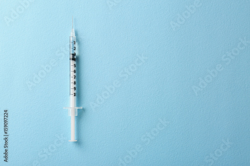 Medical syringe on color background