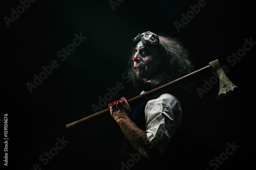 Portrait d'un clown sadique, une hache ensanglanté sur son épaule