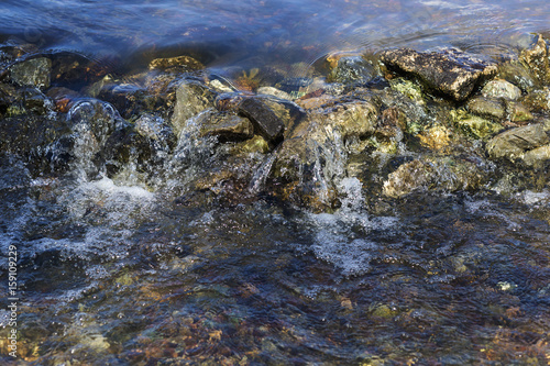 Stream flowing over stones rough rocks