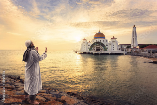 Muslim pray at the Malacca Straits Mosque ( Masjid Selat Melaka) near Malacca Town, Malaysia