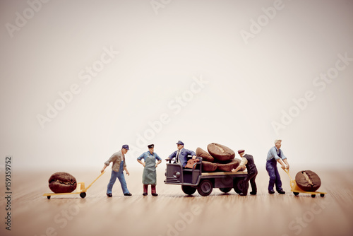 Miniature workers loading coffee beans on truck