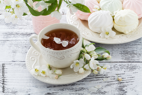 marshmallow or zefir dessert on white plate with branches of blooming apple