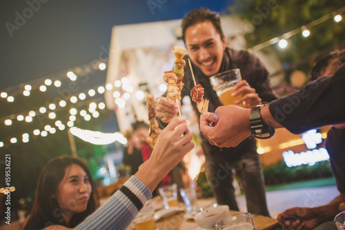 Happy Group of friends toasting and drinking beer at bbq party,vintage style.