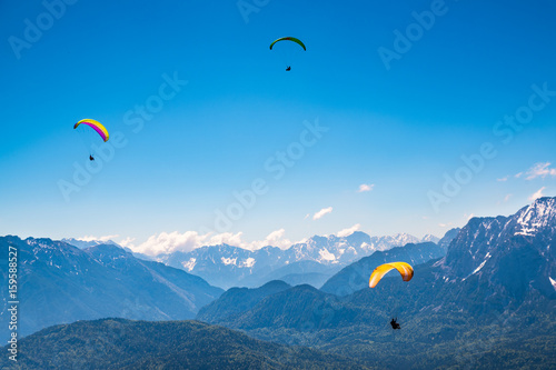 Drei Paraglider in den Alpen
