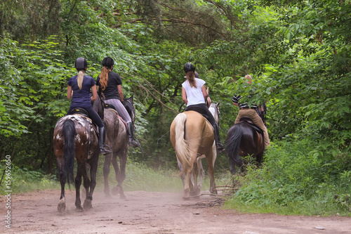 Group of friends riding horses in the forest