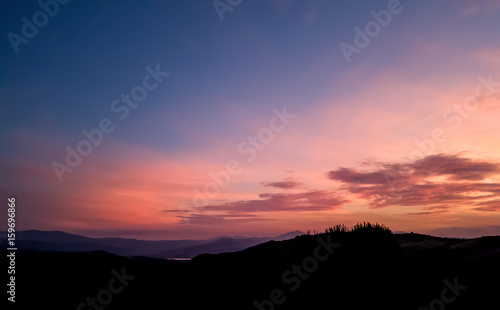 silhouette landscape under sunset sky in spring with clouds in the background, spring time at dusk