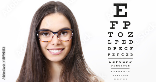 smile female face with spectacles on eyesight test chart background, eye examination ophthalmology concept