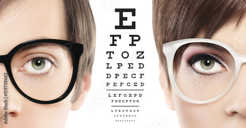 eyes and eyeglasses close up on visual test chart, eyesight and eye examination concept in white background