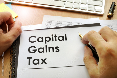 Hands holding documents with title capital gains tax CGT.