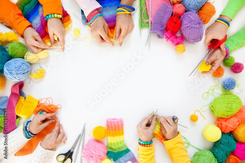 Women crochet and knitting from colored yarn. View from above.