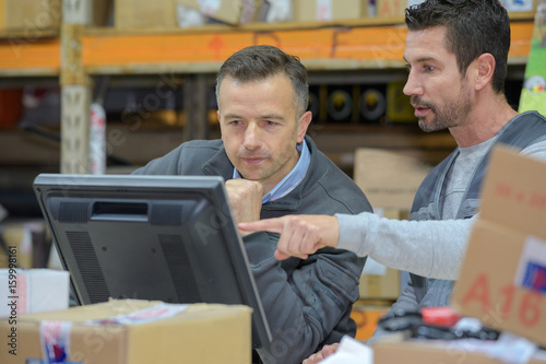 warehouse worker and manager using computer in a warehouse