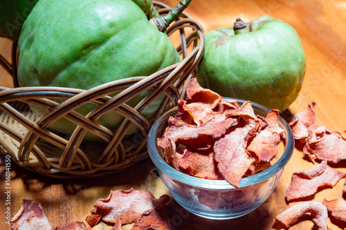 Dry garcinia in glass bowl with green Garcinia atroviridis fruit. Garcinia is healthy herb food that has high vitamin C and hydroxy citric acids (HCA) for diet.