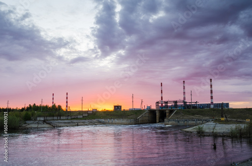 Gas power plant during sunset. Spillway and lake foreground. Energy industry concept.
