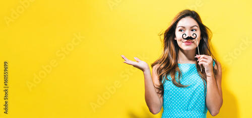  Young woman holding paper party stick
