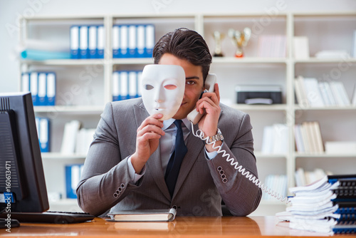 Businessman with mask in office hypocrisy concept