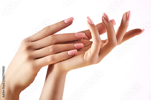 Beautiful woman's hands on light background. Care about hand. Tender palm. Natural manicure, clean skin. Pink nails