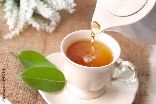 Close up pouring hot black tea in a white tea cup , Tea ceremony time concept