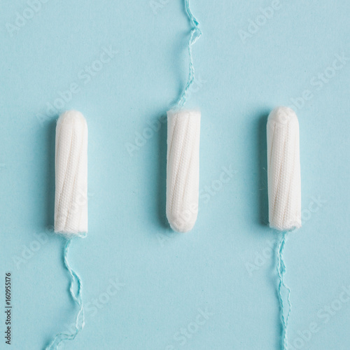 Menstrual tampon on a blue background. Menstruation time. Hygiene and protection