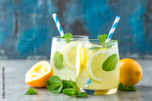 Lemonade or mojito cocktail with lemon and mint, cold refreshing drink or beverage with ice.