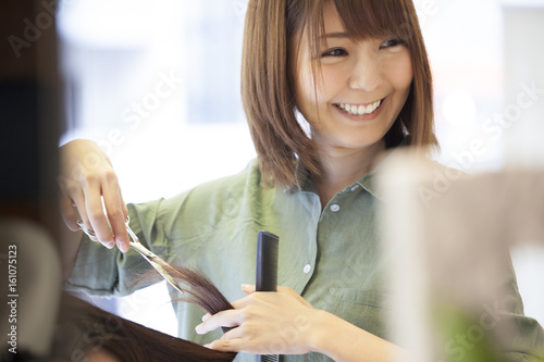 Hairdresser is cutting hair