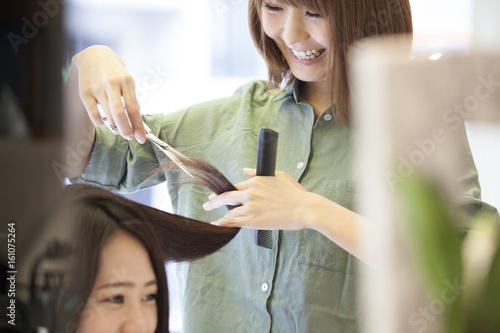 Hairdresser is cutting women's hair