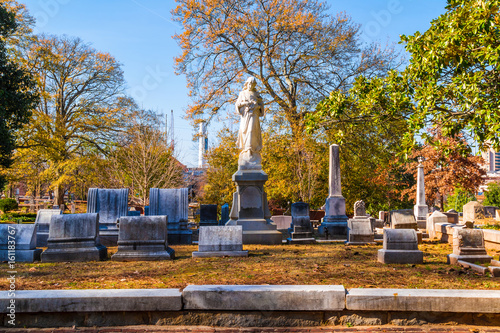 Group of tombstones and sculpture of Virgin Mary on the Oakland Cemetery in sunny autumn day, Atlanta, USA