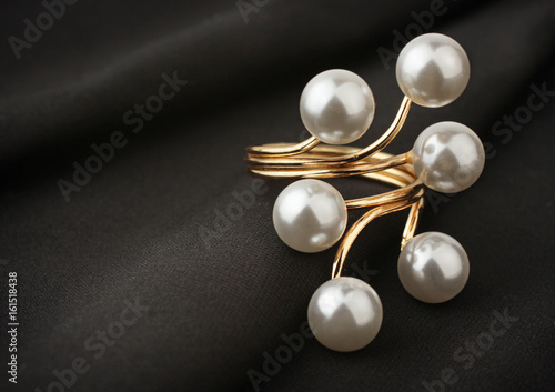jewelry ring with pearl on black cloth, soft focus