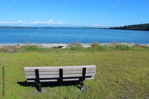 An empty bench with a beautiful bay view waiting for someone to sit and relax 