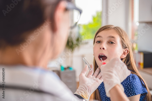 Female doctor taking a throat culture