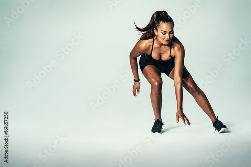 Fitness woman running over grey background