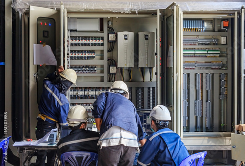 Engineer working on checking and maintenance equipment at wiring on PLC cabinet, Engineer checking status step up transformer