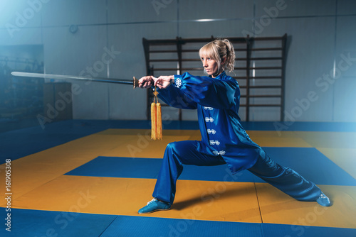 Female wushu fighter with sword in action