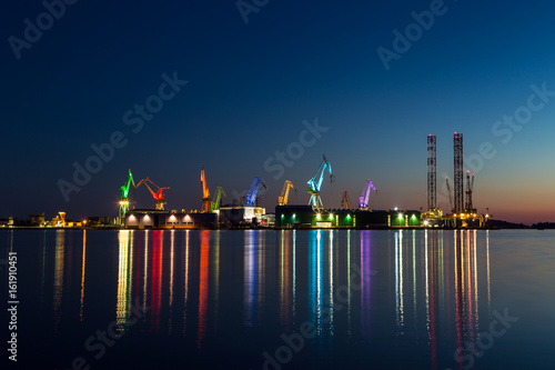 Colorful architectural lighting on giant cranes at night in Pula, Croatia