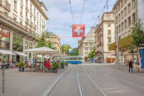 Zurich shopping street Bahnhofstrasse with tram and swiss flag