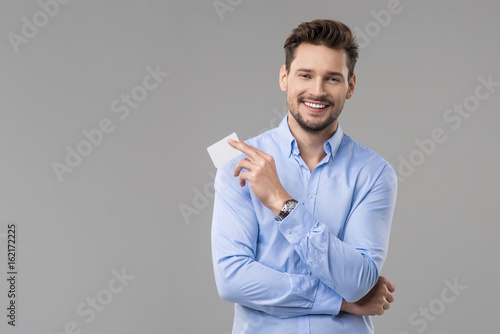 Handsome man in blue shirt with white card