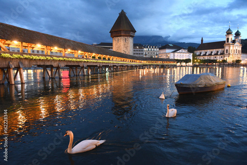 Chapel Bridge (Kapellbrucke) and Water Tower at night with swans and Jesuit Church on Lake Lucerne, Lucerne, Switzerland