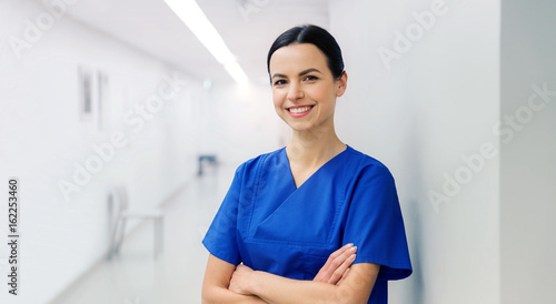 happy doctor or nurse at hospital corridor