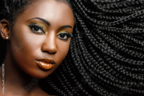 African cosmetic portrait of woman showing braided hairstyle.