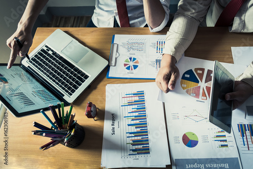 Business person analyzing financial statistics displayed on the laptop screen