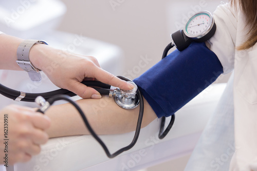 doctor measuring blood pressure from her patient close up
