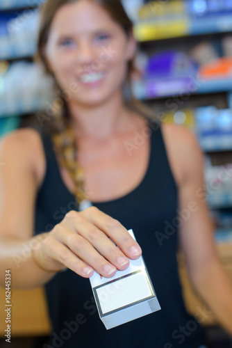 female tobacco shop owner holding cigarette packet