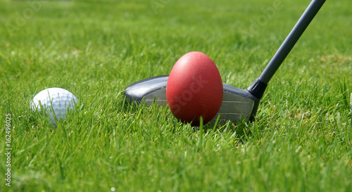 Golf-Driver mit Ei und Golfball auf Tee