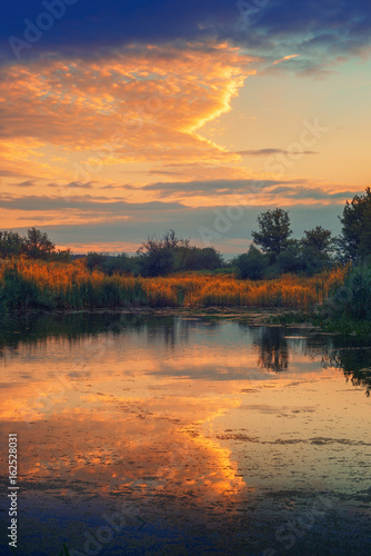 Beautiful sky reflection in river during summer sunset