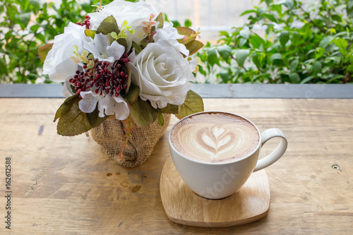 Cup of coffee on a table with flowers