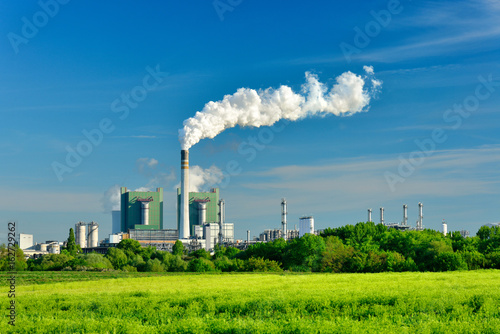 Coal Power Plant smoking and steaming against blue sky