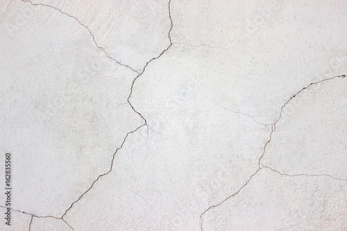 white wall, the surface cracked plaster, concrete texture
