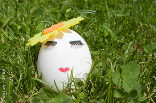 the concept of Easter to paint one egg, make up on green grass