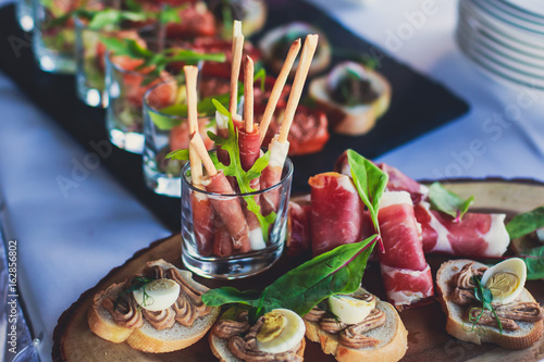 Decorated catering banquet table with different food appetizers assortment on a party 